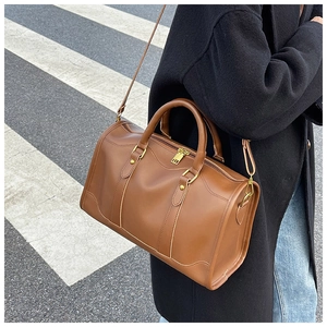 Street style view of a brown vintage Boston pillow bag with top handles and shoulder strap