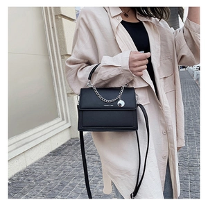 Détail du sac bandoulière enveloppe noir avec chaîne argentée et sangle amovible