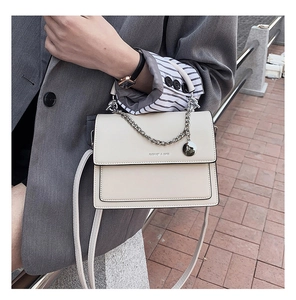 Vue détaillée du sac bandoulière crème avec chaîne argentée et lettrage fashion