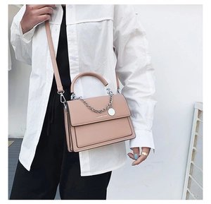 Détail du sac bandoulière rose poudré avec chaîne argentée et logo FASHION & BAGS