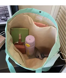 Macro view of mint green tote bag interior featuring large capacity and functional compartments