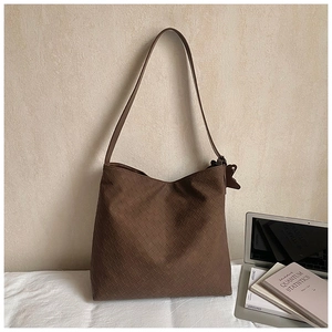 Detail of a large brown woven hobo bag showing intricate leather craftsmanship