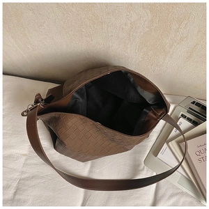 Top view of spacious brown woven leather tote showing internal compartment and texture