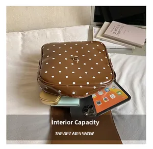 Detailed interior of polka dot leather shoulder bag showing large storage capacity