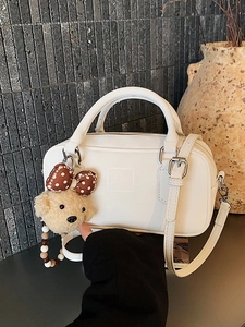 Sac bowling minimaliste en cuir blanc avec breloque ours et bandoulière réglable