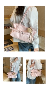 Close-up of pink glossy tote bag with metal buckle details and beige plush bear charm