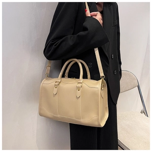 Detailed view of beige Boston pillow bag with matte leather texture and adjustable strap