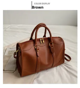 Brown Boston handbag detail with faux leather texture and gold metal hardware