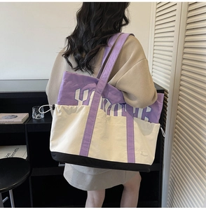 Detail view of large color-block canvas tote bag featuring purple York letter printing
