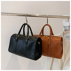 Minimalist leather Boston bags in black and brown with gold hardware on display