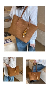 Detail of vintage brown tote bag featuring suede texture and wooden bead tassel accessory