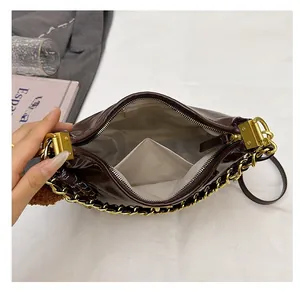 Detailansicht des geräumigen Innenfachs und des cremeweißen Futters der braunen Hobo-Tasche
