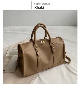 Detail view of khaki matte leather Boston pillow bag with golden zippers and strap