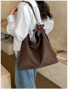 Detail of dark brown woven hobo bag with star-shaped charm and large capacity