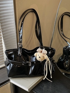 Large black patent leather tote bag with plush puppy charm and adjustable buckle straps