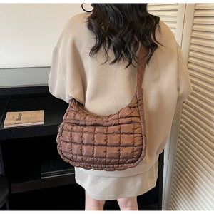 Vue détaillée du sac à bandoulière matelassé marron foncé en tissu texturé doux