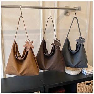 Detailed texture of woven hobo bags with star charms in brown, coffee and grey colors