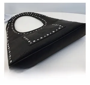 Close-up of vintage black leather shoulder bag showing rivet details and wrinkled texture