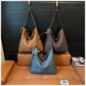 Detailed view of woven leather tote bags in brown and grey with star charms