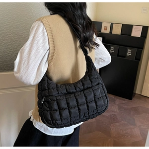 Vue arrière d'un sac cabas noir matelassé avec bandoulière réglable sur le mannequin