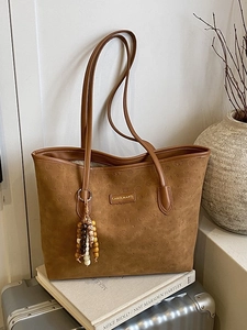 Brown suede tote bag with embossed cartoon dog patterns and wooden bead charm accessory