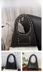 Detail view of black vintage motorcycle tote bag with silver rivets and oily leather texture