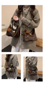 Detail der dunkelbraunen Lackleder-Schultertasche mit Goldkette und Teddybär-Anhänger