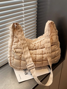 Sac fourre-tout matelassé beige avec bandoulière réglable et poche zippée devant