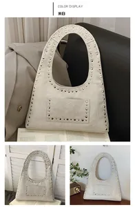Detail view of cream vintage tote with silver studs and cracked leather texture