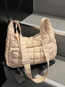 Sac fourre-tout matelassé crème avec bandoulière réglable sur un support minimal