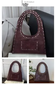 Detail of vintage brown leather tote bag with silver studs and integrated curved handle