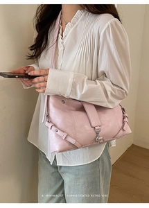 Detail of pink faux leather crossbody bag showing litchi texture and metal buckle clasp