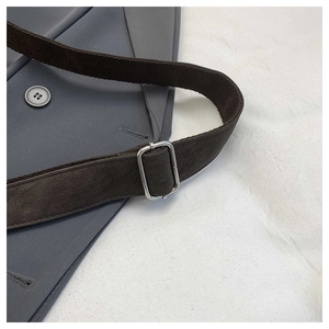 Detail of adjustable dark brown strap with silver buckle on minimalist grey canvas bag