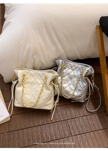 Détail de sacs matelassés en crème et argent métallisé avec bandoulières dorées