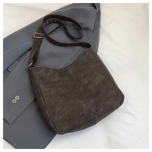 Flat lay of retro crossbody bag with textured leather and adjustable fabric shoulder strap