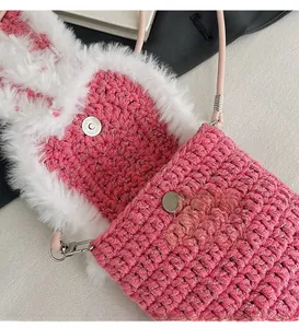 Close-up of pink crochet bag featuring silver magnetic closure and white faux fur trim
