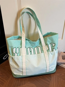 Large mint green nylon tote bag with white strap handles and side drawstring details