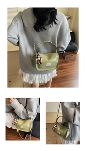 Détail du sac à main vert avocat brillant avec bandoulière chaîne et breloque poupée
