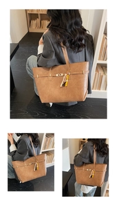 Detail of a brown tote bag with metal buckle strap and colorful beaded charm accessory