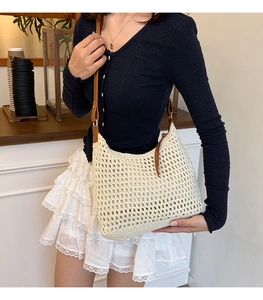 Detail of crochet hollow woven beach bag with premium brown leather shoulder strap