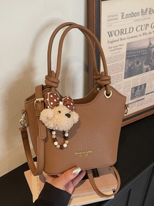 Brown lychee leather bucket bag with top handle and teddy bear charm for women