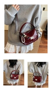 Détail du sac en cuir verni bordeaux avec chaîne argentée, perles et breloque peluche