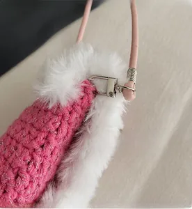 Close-up of durable silver metal hook on pink knitted shoulder bag with plush trim
