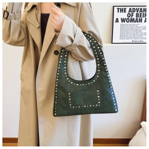 Detail of dark green leather shoulder bag with silver metal rivet studs and retro finish