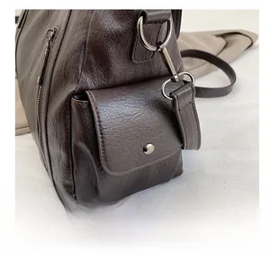 Detail view of the side pocket on this dark brown tote bag with vintage texture