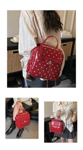 Close-up of red polka dot patent leather mini backpack with metal twist lock and chain strap