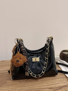 Glänzende schwarze Lackleder-Schultertasche mit Goldkette und süßem Bärenanhänger