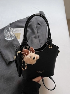 Litchi pattern black bucket bag with plush bear charm for stylish commute outfits