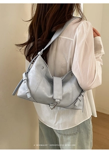 Detail of light blue minimalist retro tote bag with glossy finish and metal hardware