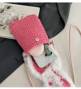 Pink hand-crocheted phone bag featuring magnetic buckle and soft plush trim details